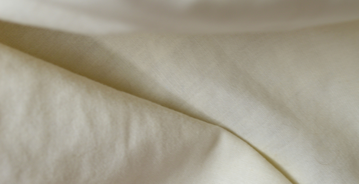 Close-up of white linen fabric, one of the best summer fabrics for hot weather.