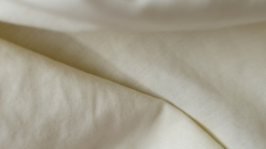 Close-up of white linen fabric, one of the best summer fabrics for hot weather.