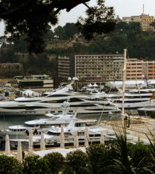 monaco-gp-harbour-luxury-yachts Luxury mega yachts docked in Monaco's Port Hercules, framed by Mediterranean greenery and iconic Monte Carlo architecture during the Monaco GP Fashion 2026 showcase.