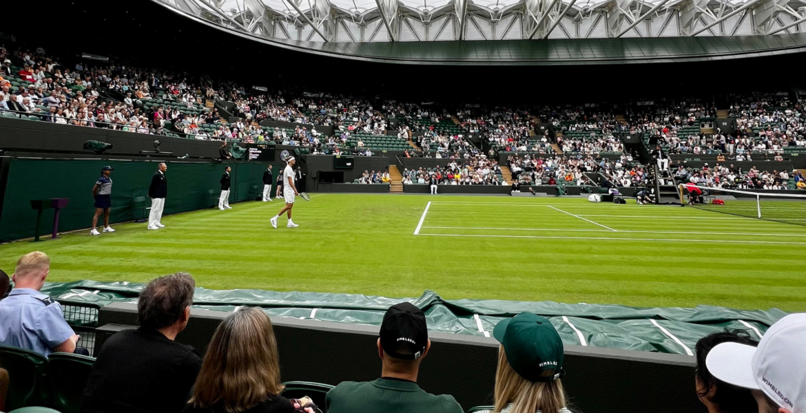 Wimbledon 2026 outdoor grass courts featuring a professional tennis player in a white uniform preparing for a match on Centre Court.