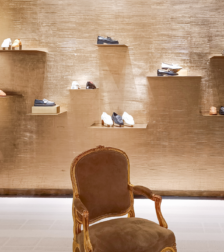 What is a Luxury fashion house boutique showcasing handcrafted leather shoes and timeless craftsmanship.