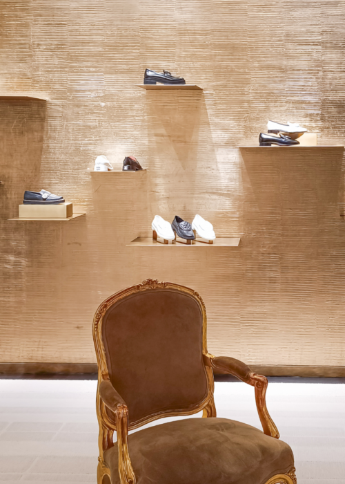 What is a Luxury fashion house boutique showcasing handcrafted leather shoes and timeless craftsmanship.