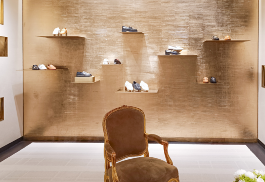 What is a Luxury fashion house boutique showcasing handcrafted leather shoes and timeless craftsmanship.