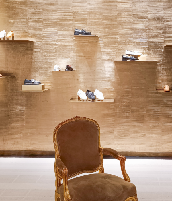 What is a Luxury fashion house boutique showcasing handcrafted leather shoes and timeless craftsmanship.